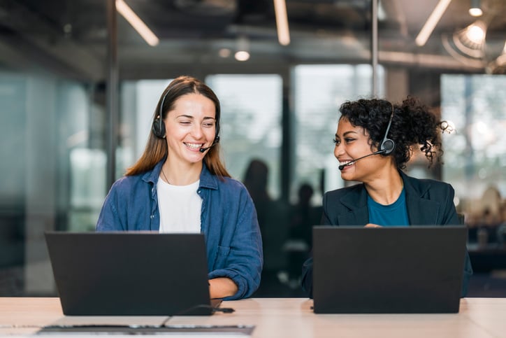 Two staff interpreters share a smile between calls.