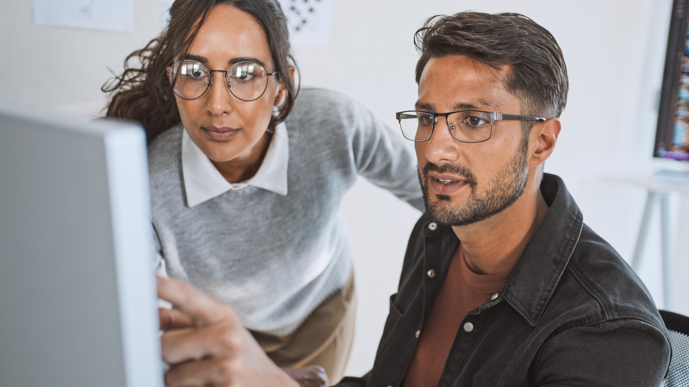 two employees review AI translation on computer screen