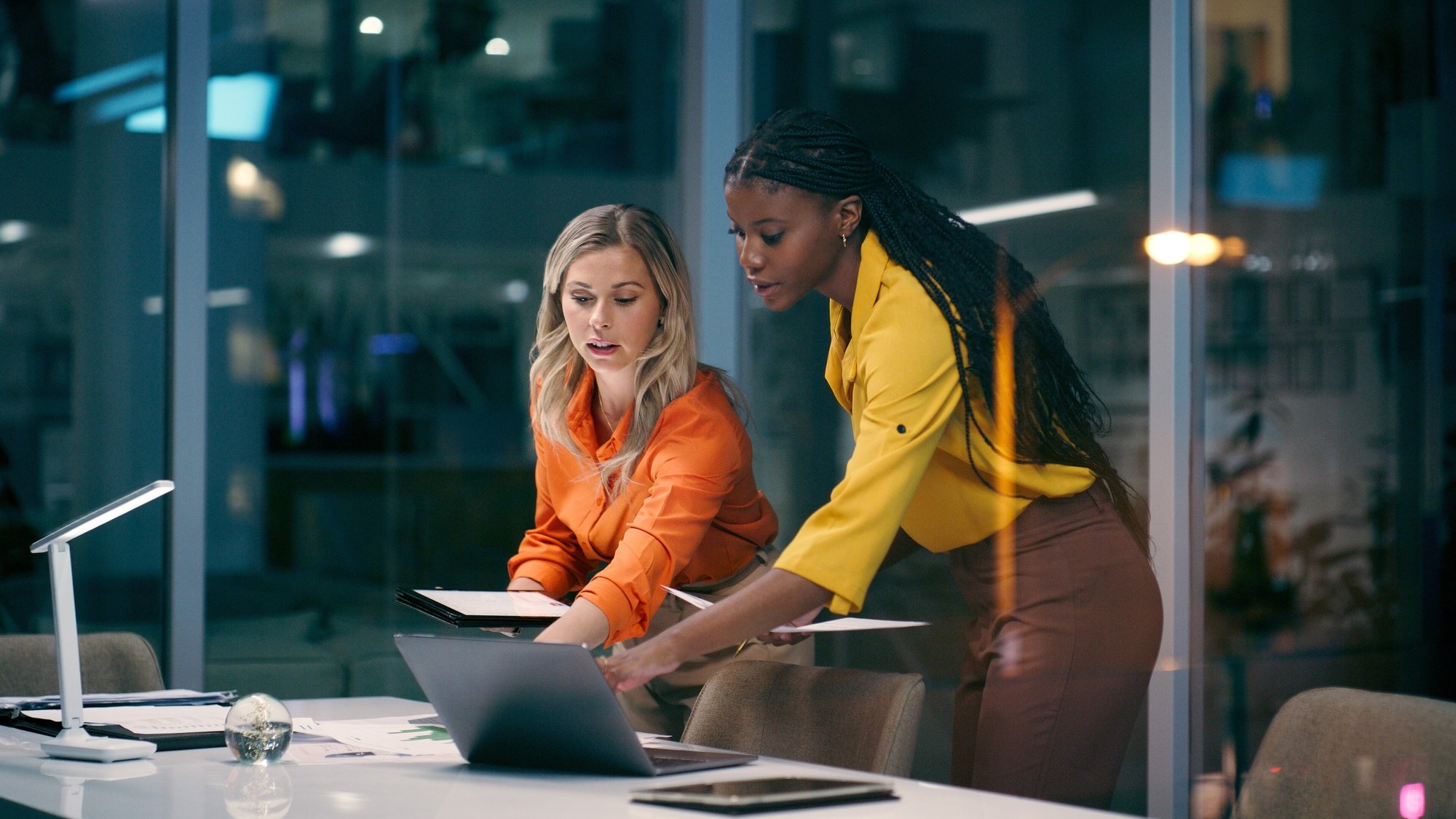 Two employees review localised training content together.