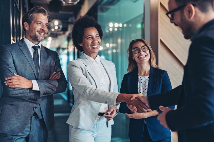 Group of business people shaking hands while discussing machine translation