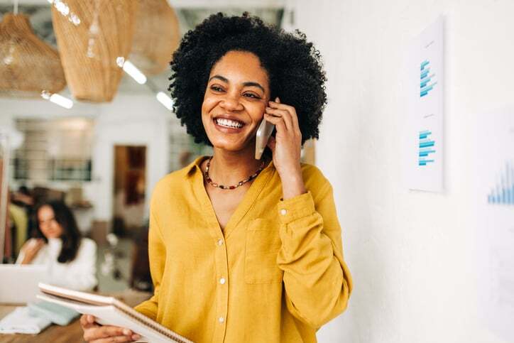 Business woman smiling on phone while talking to a LanguageLine Business Development Manager