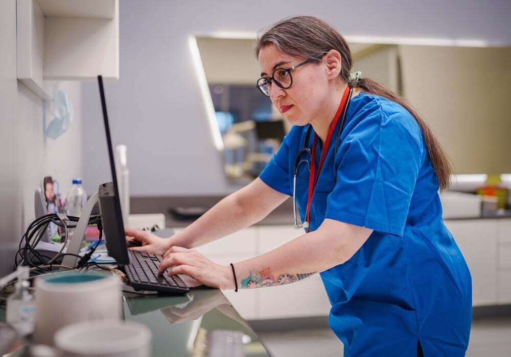 A healthcare worker reviews information in an EHR system