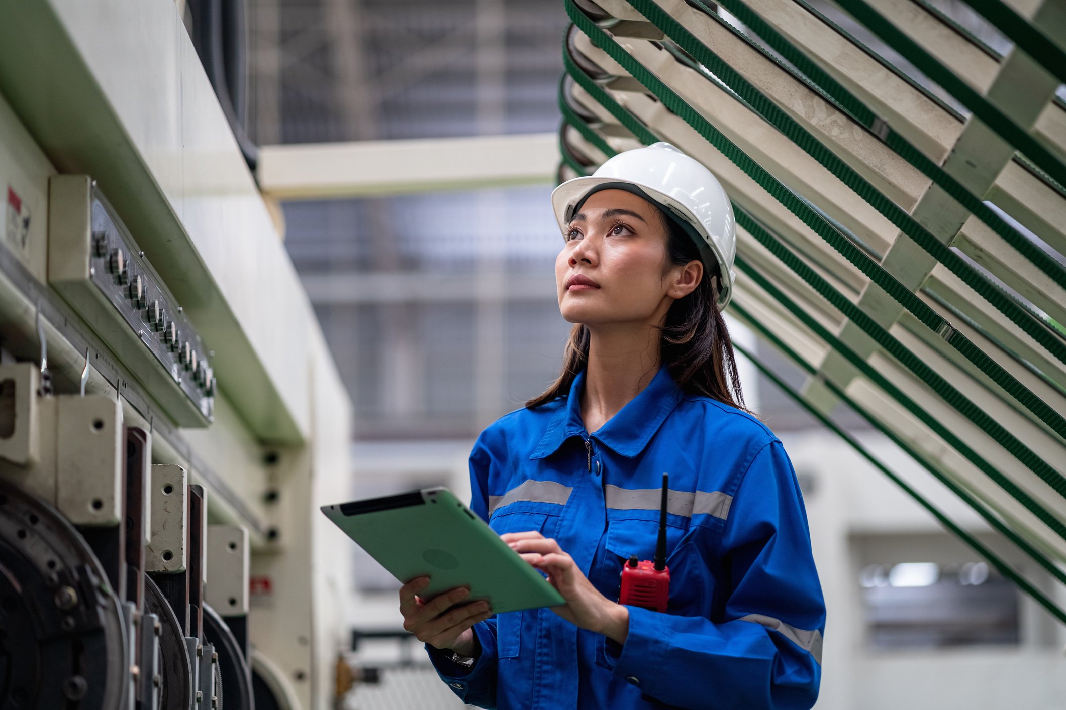 A manufacturing worker reviews translated documentation on a tablet.