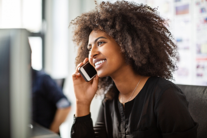 A woman smiles as she talks to a manufacturing representative in her language of choice.