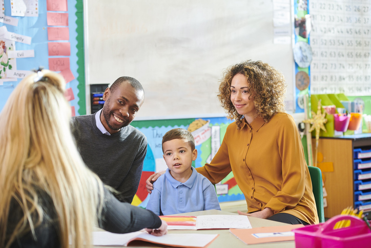 A mom and her son meet with a teacher with an in-person interpreter.