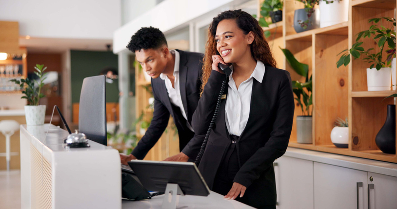 A hotel worker answers the phone with an interpreter on the line.