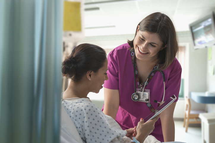 A doctor speaks to a patient with the help of an interpreter through a tablet.