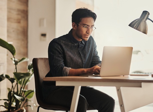 A desktop publishing pro focuses on a project on his laptop