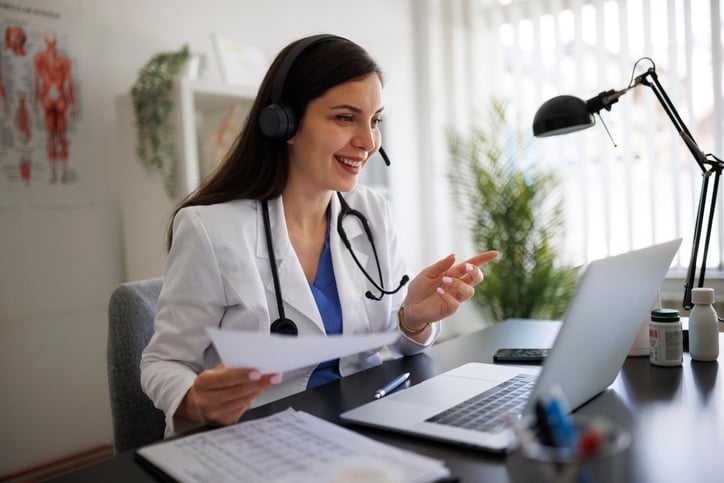 A doctor discusses test results with a patient during a telehealth call supported by an interpreter