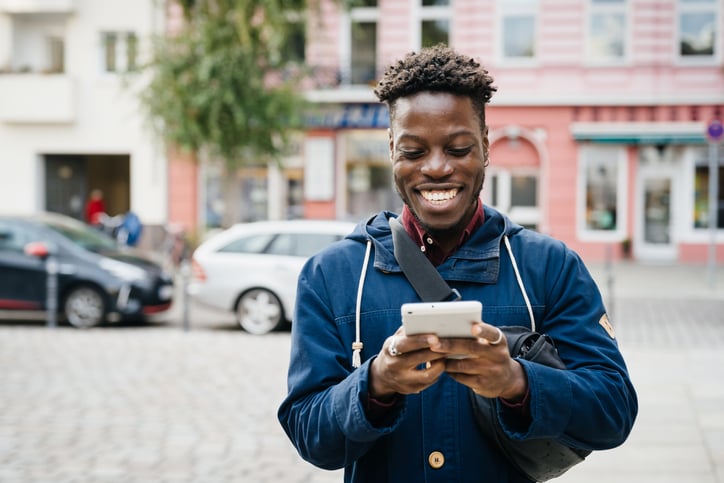 Man smiling at phone as he reviewes GDPR-compliant data policy