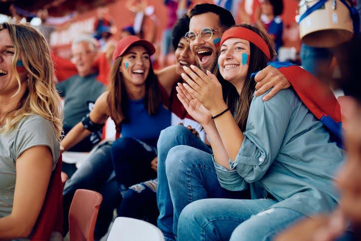 Fans in a stadium cheer for their team.
